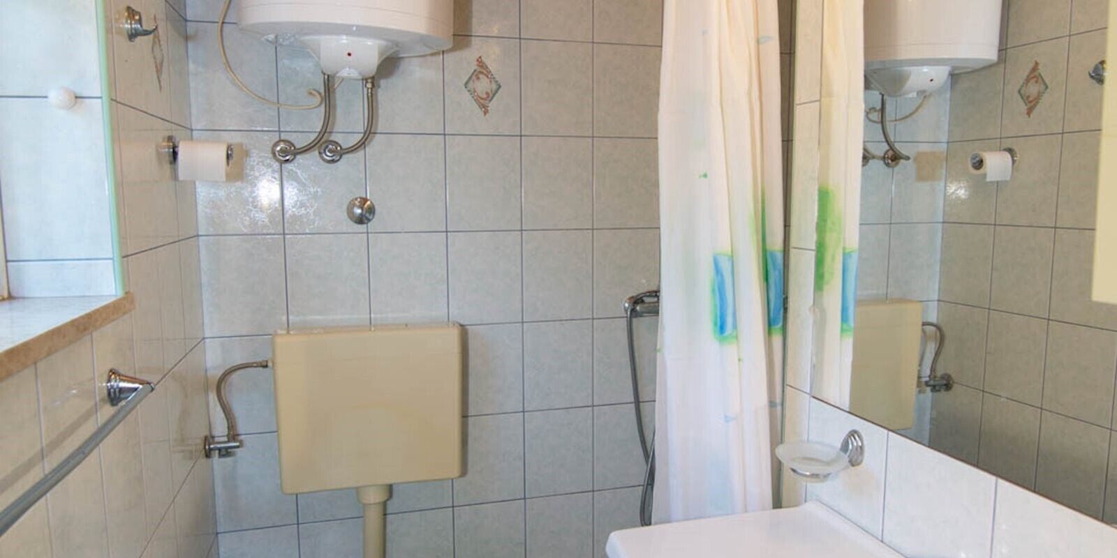 Une salle de bain avec des toilettes, un lavabo et une douche.