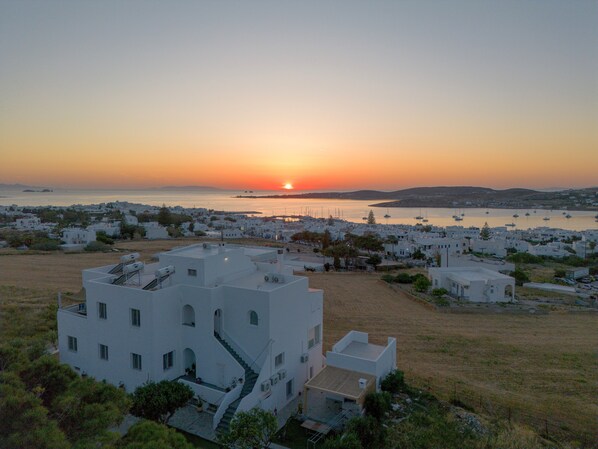 A coastal town with white buildings, a clear sky, and a sunset over the sea. - Holiday Home 'Saphhire' with Sea View, Shared Terrace and Wi-Fi (Paros)