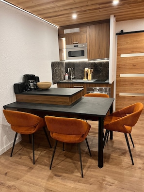 Eine moderne Küche mit Holzschränken, einem eingebauten Ofen und einer schwarzen Arbeitsplatte.