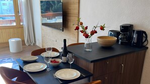 Una cocina moderna con armarios de madera, una mesa de comedor con platos, vasos y un jarrón de flores.