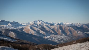 A mountainous landscape with snow-covered peaks and a clear sky.