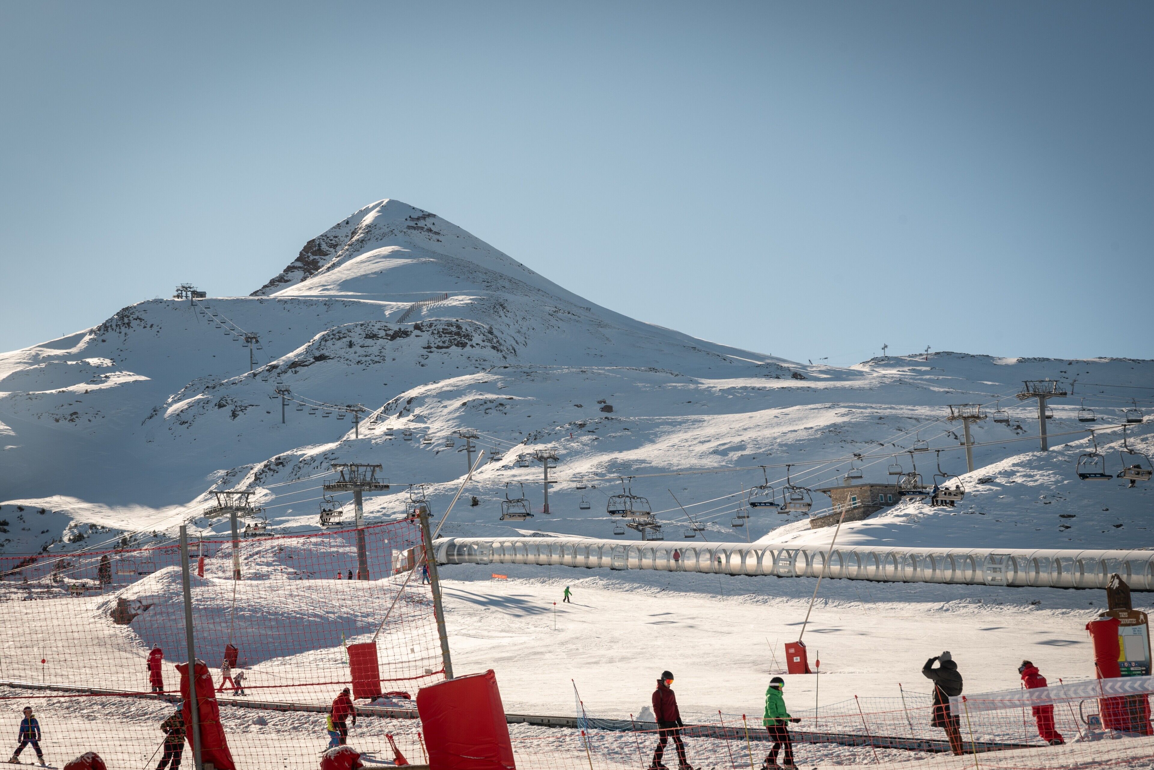 Une montagne enneigée, dotée de remontées mécaniques et d’une piste de ski.