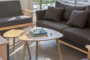 Una sala de estar moderna con un sofá gris, una mesa de centro de madera y un juego de mesa.