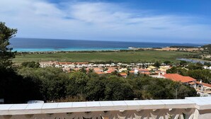 A coastal town with houses, a beach, and a clear sky. - Bouganville Apartment in Son Bou with Sea View (ALAIOR)