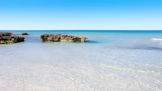 A beach with clear water, rocks, and a clear sky. - Bouganville Apartment in Son Bou with Sea View (ALAIOR)