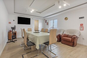 Ett modernt vardagsrum med ett matbord, stolar, en soffa och en tv som är monterad på väggen.