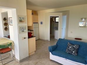 A compact living space with a kitchenette, a dining area, and a sofa. - NiceView Apartment in Son Bou with Sea View – Ideal for Couples (ALAIOR)