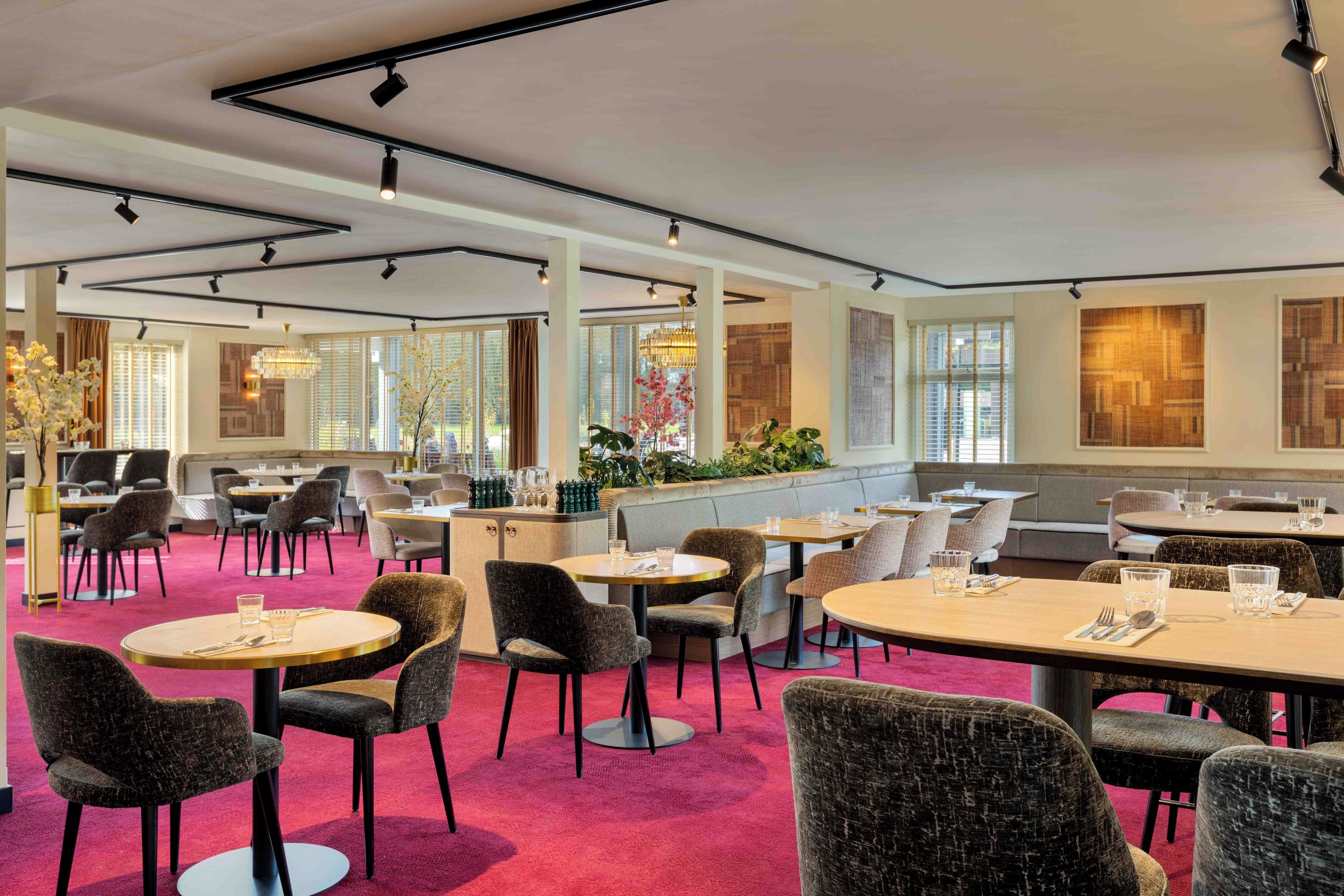 A restaurant with round tables, chairs, and a bar area.