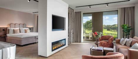 A modern living room with a fireplace, a sofa, a TV, and a view of the outdoors.