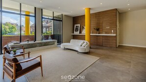 A modern living room with a sofa, a coffee table, and a large window. - Modern and Complete Stays in Gramados Tourist Center - Cbgs (Gramado)