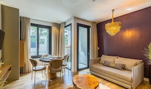 A modern living room with a sofa, dining table, chairs, and a chandelier. - Modern and Complete Stays in Gramados Tourist Center - Cbgs (Gramado)