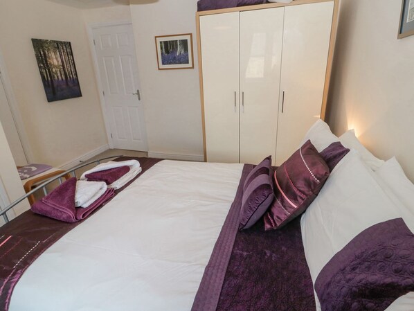 Une chambre à coucher avec un lit, une armoire et une porte.