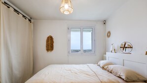 Una camera da letto con un letto grande, una finestra e un lampadario.