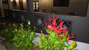An outdoor area with a covered seating area, plants, and a wall with decorative panels. - Sweden Villa Galle (Galle)