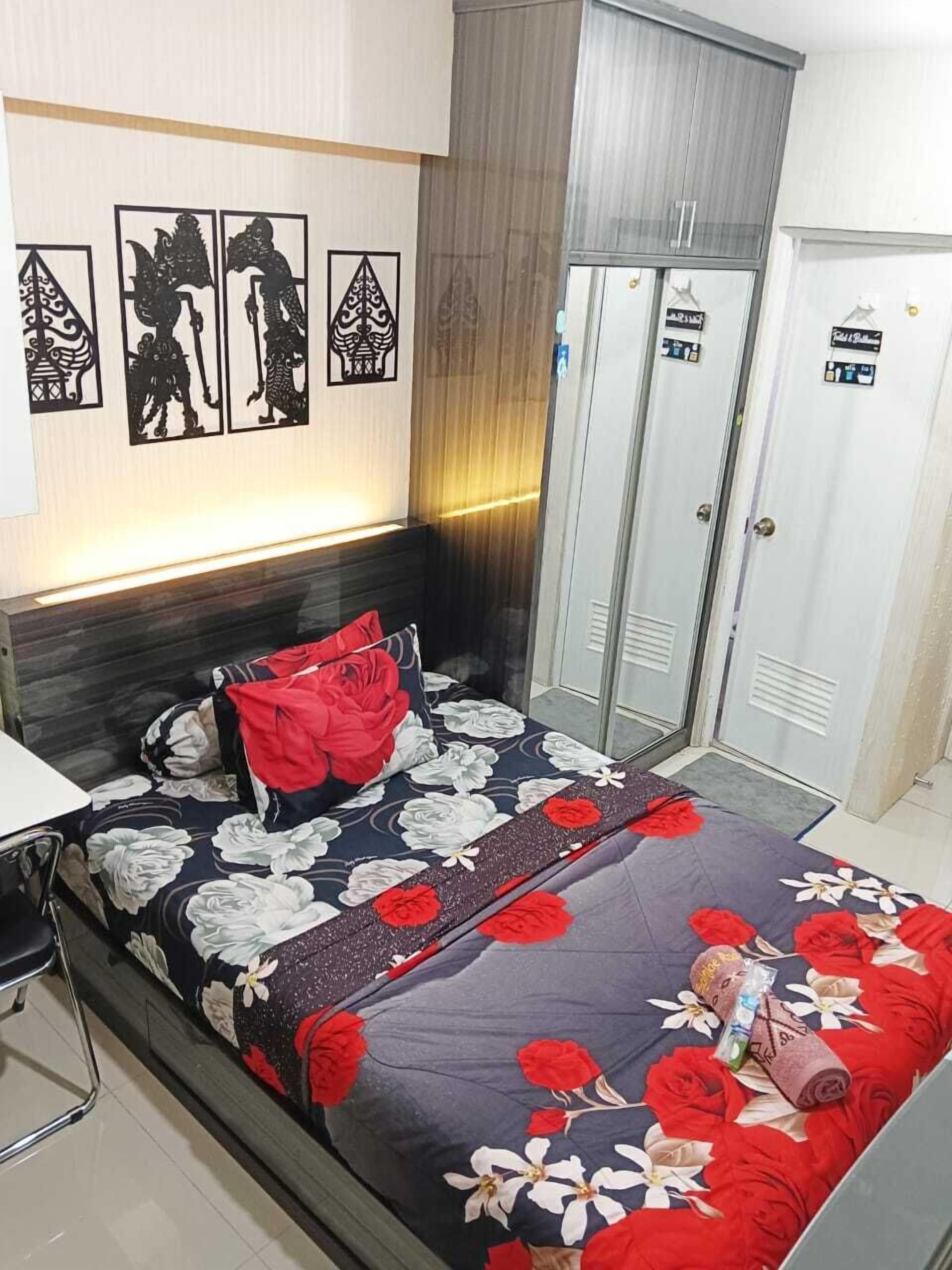 A neatly arranged bedroom with a bed, a nightstand, a wardrobe, and a wall with decorative panels.