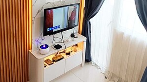 Ein modernes Wohnzimmer mit Marmorwand, einer an der Wand befestigten Fernseher, einer Holzvertäfelung und einer Decken-Klimaanlage.