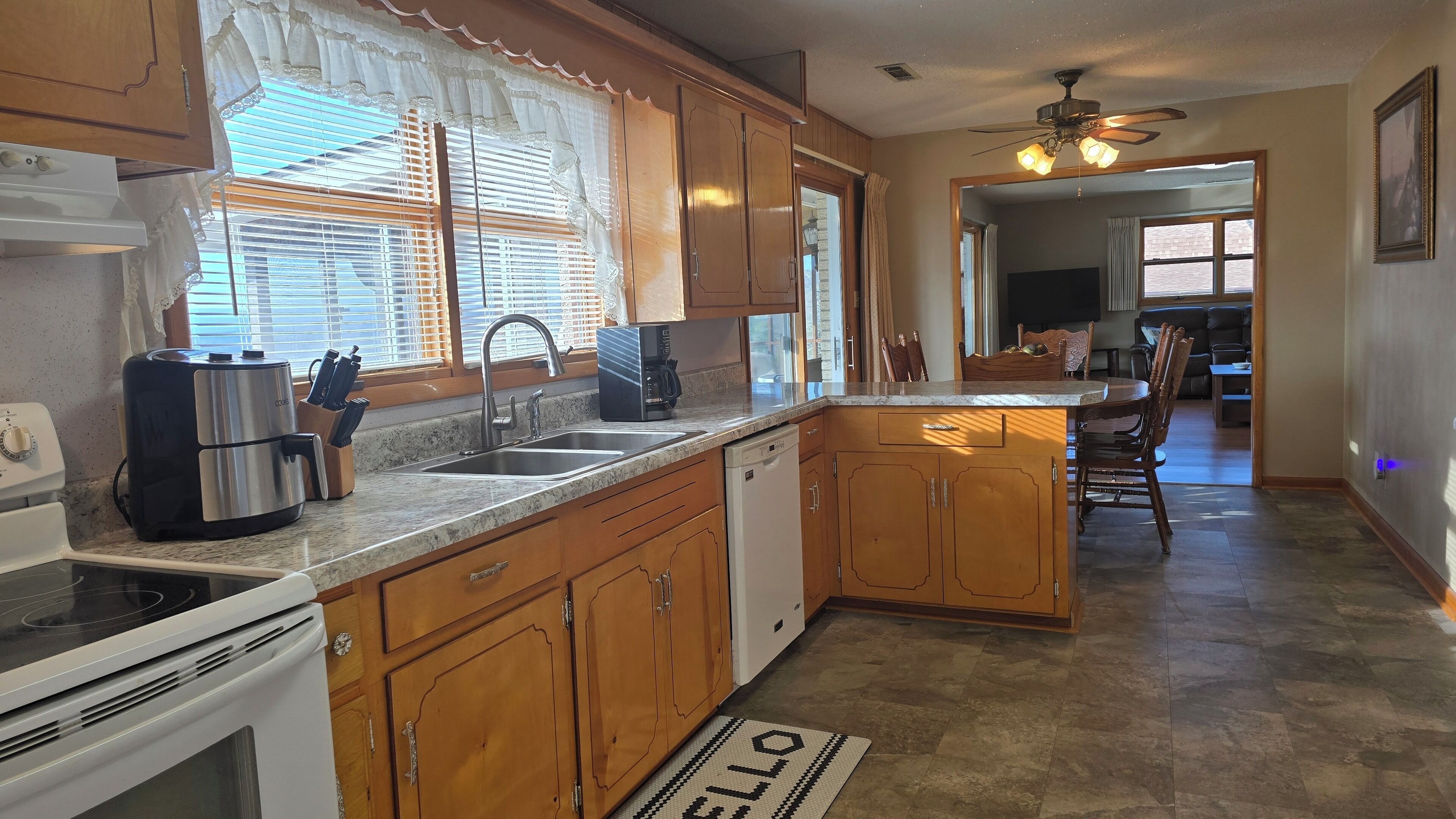A kitchen with wooden cabinets, a stainless steel range, a dishwasher, and a coffee maker.