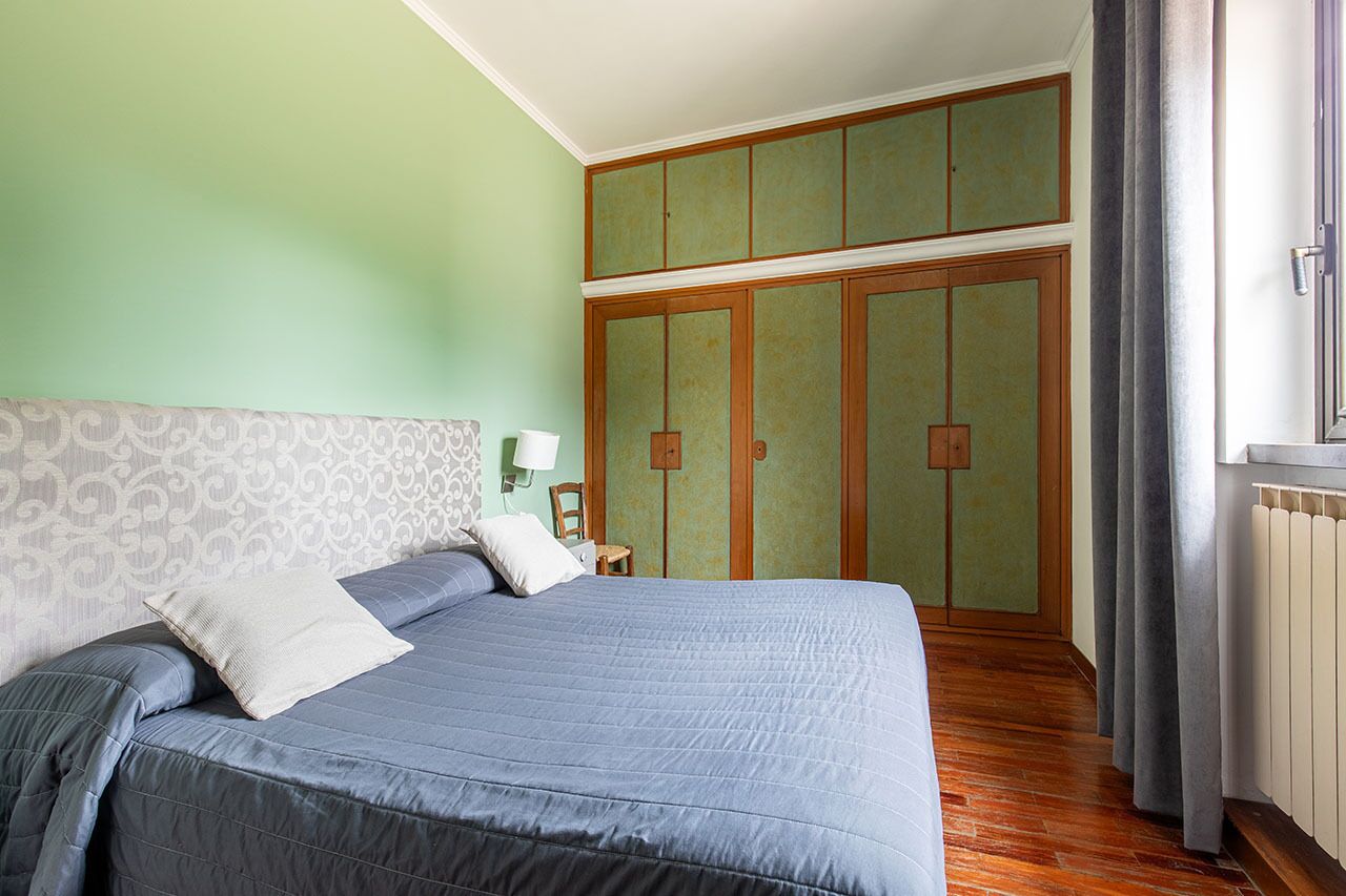 Ein Schlafzimmer mit einem großen Bett, einem Schrank und einer Heizung.