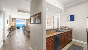 A modern kitchen with a granite countertop, stainless steel appliances, and a view of the ocean. - Huge Balcony-Spectacular Views-Penthouse 4BR/4Bath (Panama City Beach)