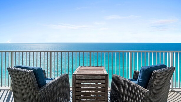 A balcony with wicker chairs and a small table, overlooking a clear blue sea. - Huge Balcony-Spectacular Views-Penthouse 4BR/4Bath (Panama City Beach)