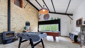 A room with a foosball table, a fireplace, a window with a view, and a billiards table. - Gîte La Ferme Du Mesnil with Private Terrace, Wi-Fi, and Air Conditioning (Sèvremont)