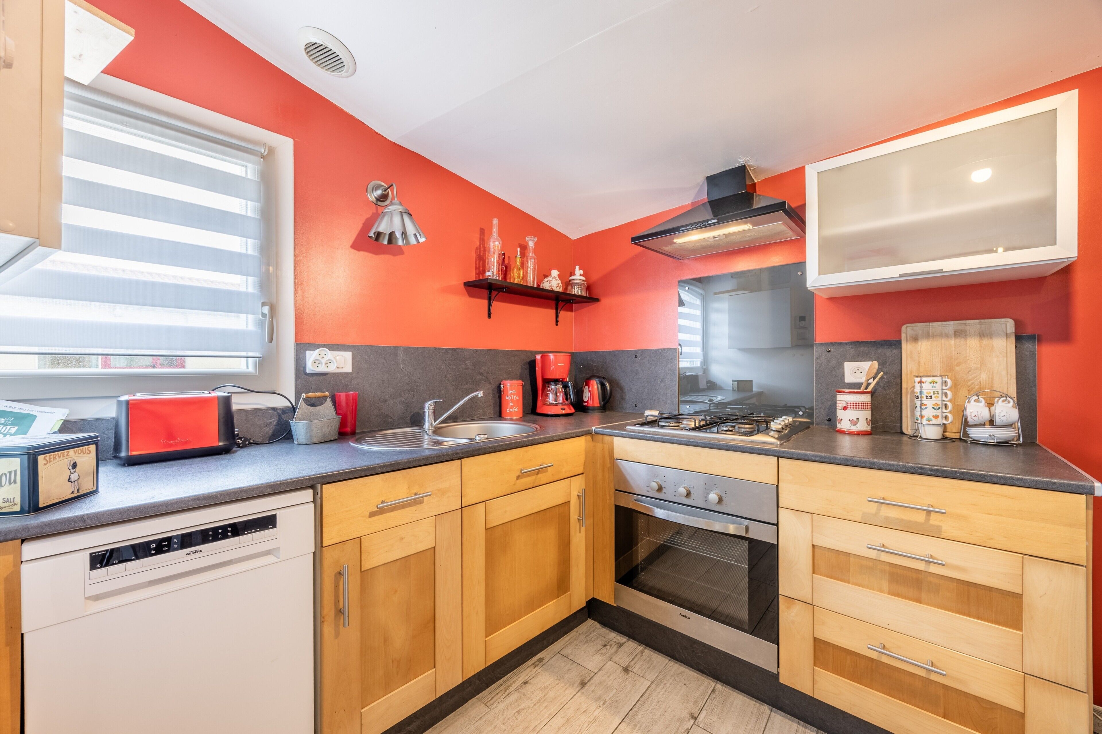 Una cocina con armarios de madera, lavavajillas, estufa y microondas.