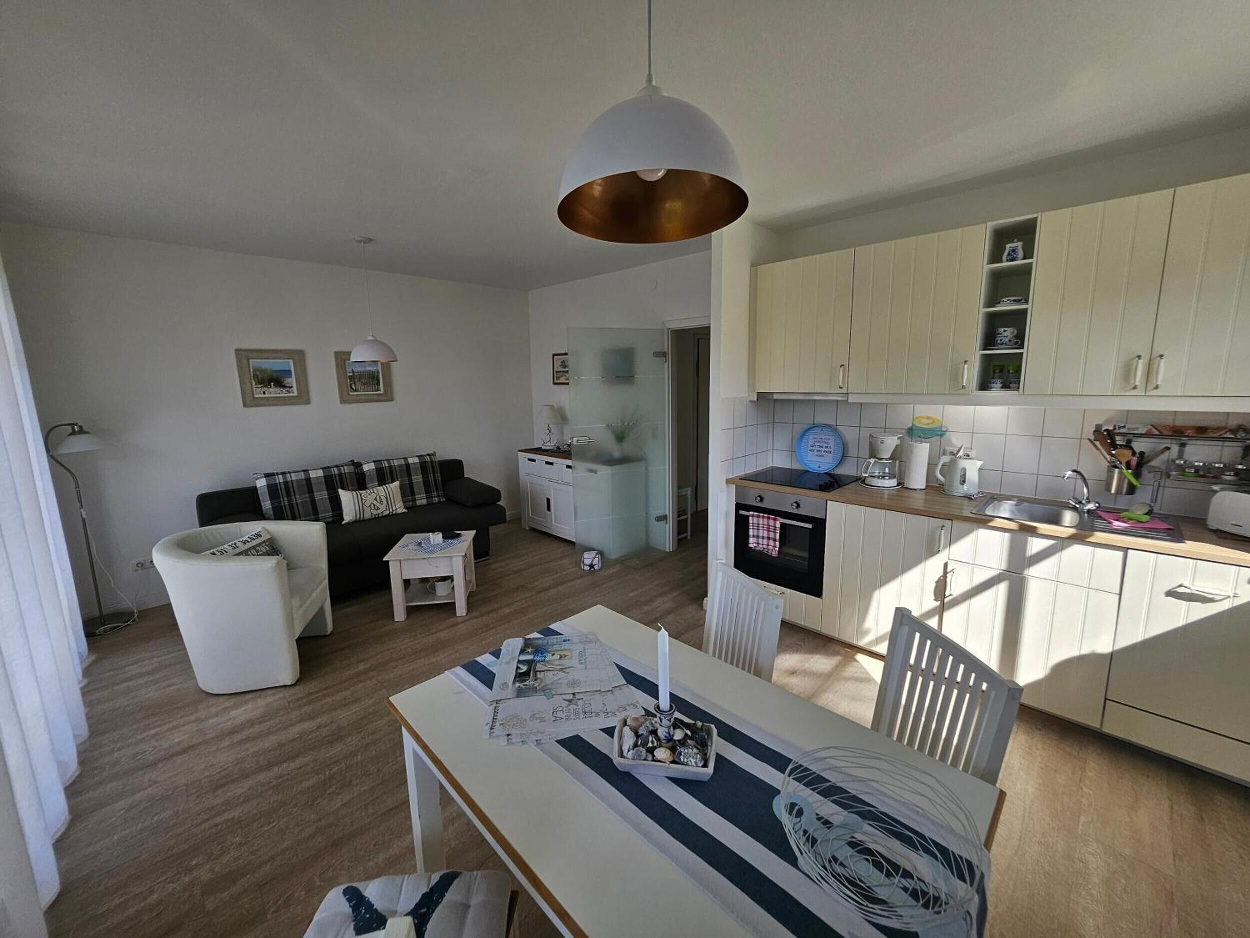 Un espacio habitable compacto con kitchenette, comedor y sofá.