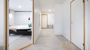 Ein modernes Hotelzimmer mit einem Bett, einem Nachttisch und einer kleinen Pflanze.