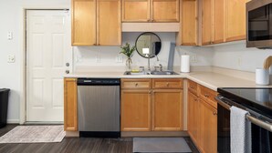 A kitchen with wooden cabinets, a dishwasher, a sink, and a microwave. - Family Gem in Pelham 3BR/2Bath 1 LEVEL Pet friendly home (Pelham)