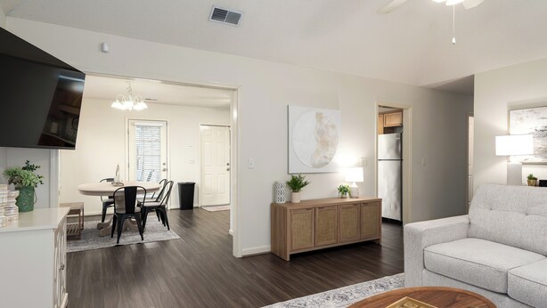 A modern living room with a sofa, a coffee table, and a dining area with a table and chairs. - Family Gem in Pelham 3BR/2Bath 1 LEVEL Pet friendly home (Pelham)