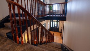 A grand staircase with wooden balusters leading to a second-floor landing.