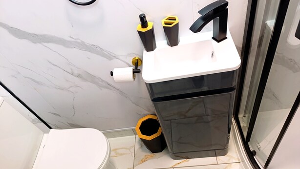Een moderne badkamer met toilet, bidet en prullenbak.