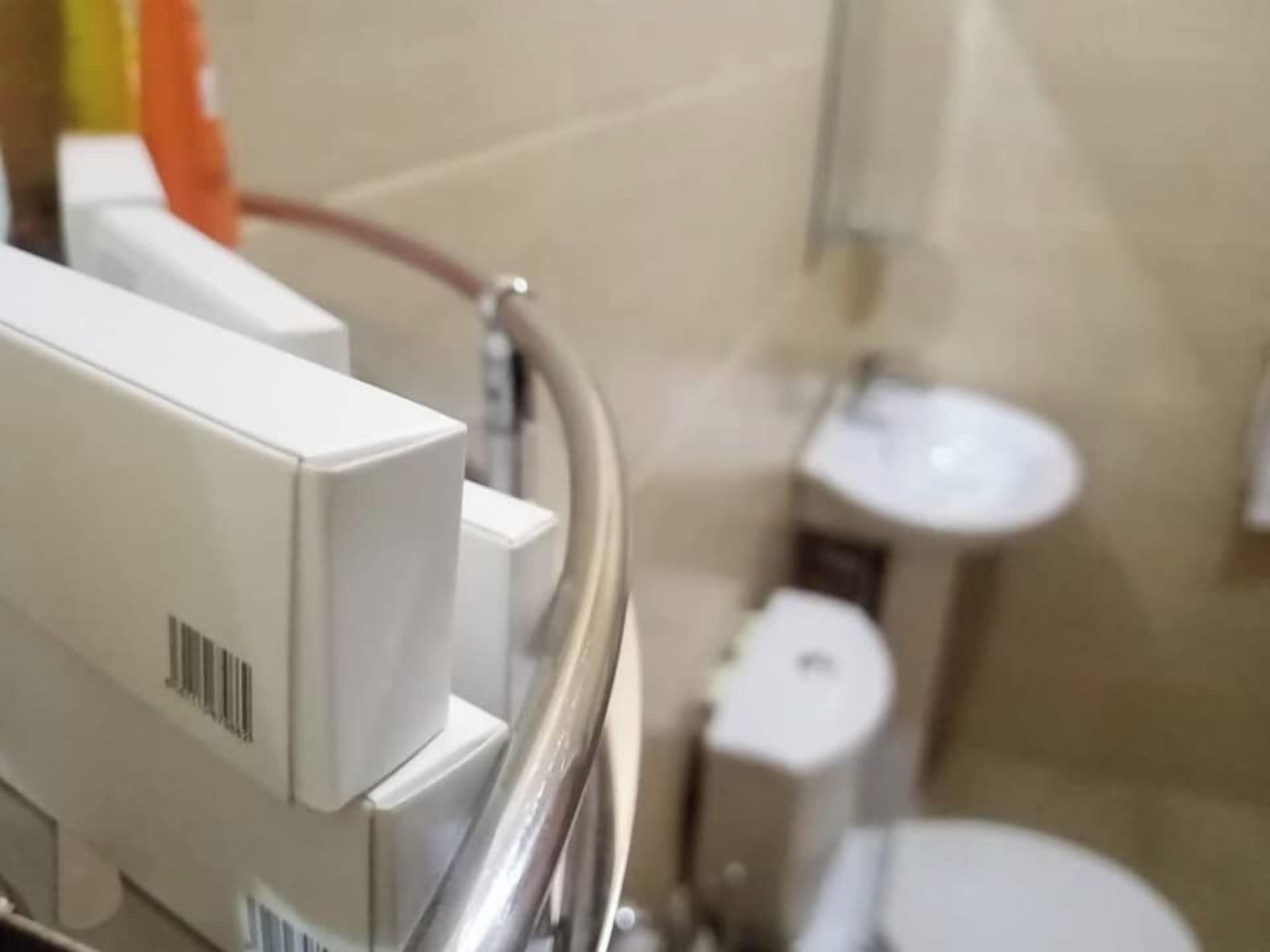 Een badkamer met toilet, wastafel en een wit kastje.