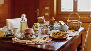 A wooden table with a variety of tea cups, a pie, and a basket. - 'Gratacul' Room with Mountain View, Shared Terrace (Valtournenche)