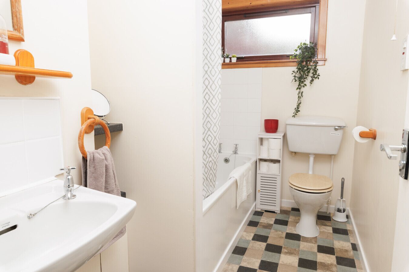 A compact bathroom with a sink, toilet, and shower.