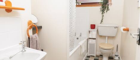 A compact bathroom with a sink, toilet, and shower.