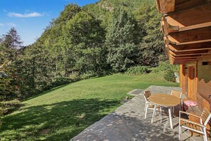 Une cabane en bois avec un patio en pierre, une table ronde et des chaises.