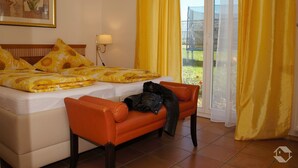 Een hotelkamer met een bed, een bank, een lamp en een raam met gordijnen.
