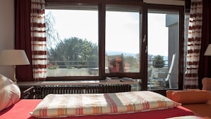 Una habitación de hotel con dos camas, vistas al exterior y un radiador.