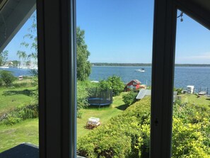 Vista de un lago con una casa, un trampolín y un bote.