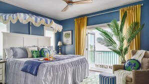 Une chambre à coucher avec un lit, une table de chevet, une chaise, une fenêtre et un ventilateur de plafond.