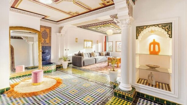 A spacious hotel lobby with a checkered floor, a large mirror, a sofa, and a decorative column. - Guéliz Marrakech-Authentic, spacious, central (Marrakech)