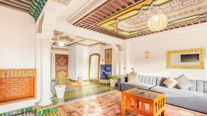 A spacious living area with a patterned floor, a grey sofa, and a wooden coffee table. - Guéliz Marrakech-Authentic, spacious, central (Marrakech)