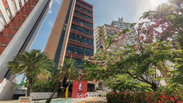 A modern building with a red and white facade, a prominent vertical tower, and a sign indicating condominiums. - Studio in Barra 600 m From the Beach Bsf0806 (Salvador)