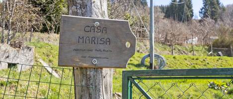 Un letrero de madera con el texto 'CASA MARISA' y texto adicional en otro idioma.