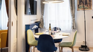 A dining area with a round table, chairs, and a pendant light. - City Suite German Chic The Imperial Balcony (Metz)