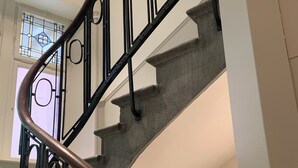 A spiral staircase with metal railings and a wooden handrail. - City Suite German Chic The Imperial Balcony (Metz)