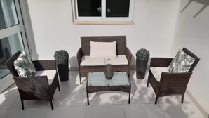 A patio with a sofa, two armchairs, a coffee table, and two decorative vases. - Modern 3BR Apartment in Swieqi (Is-Swieqi)