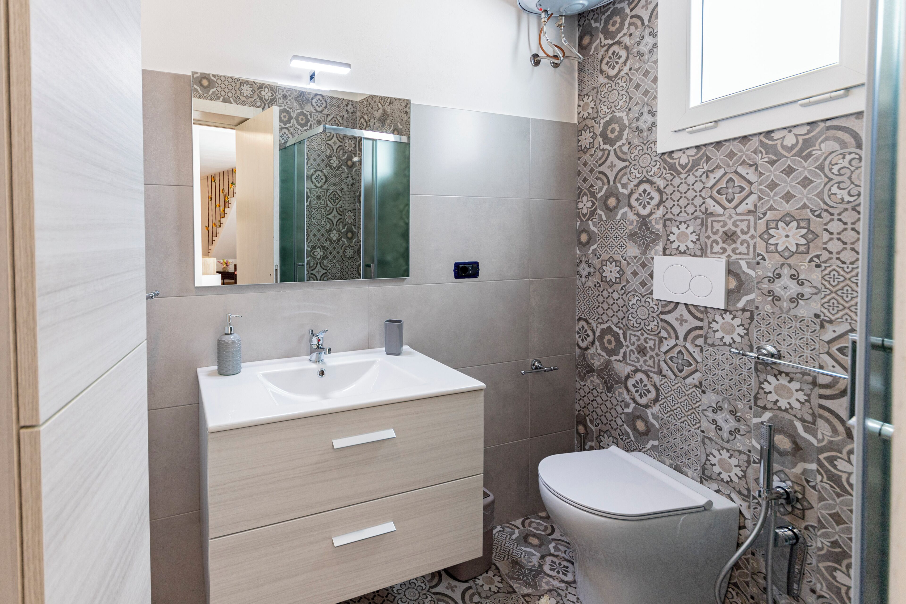 Une salle de bain moderne avec un lavabo blanc, un miroir et des toilettes.