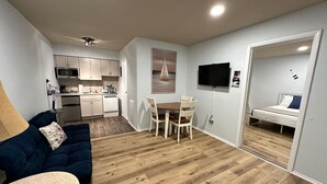A compact living space with a kitchenette, a dining area, and a bedroom. - Great Lakes Resort - Jr Suite - Suite 8 (Lexington)